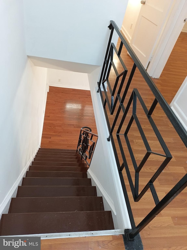 stairway featuring baseboards and wood finished floors