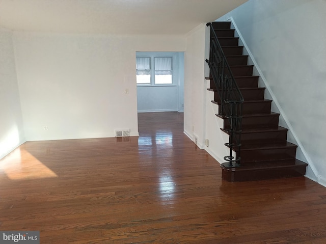 stairs with visible vents and wood finished floors