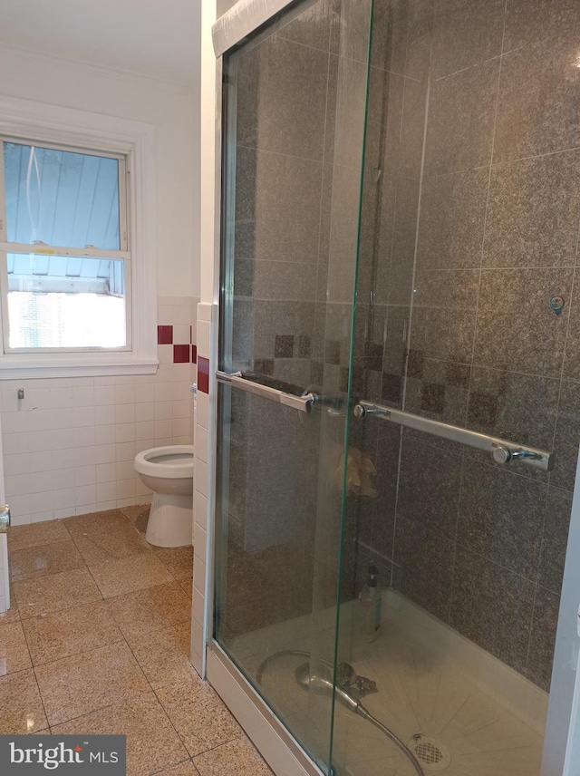 full bathroom with tile walls, toilet, a shower stall, and wainscoting