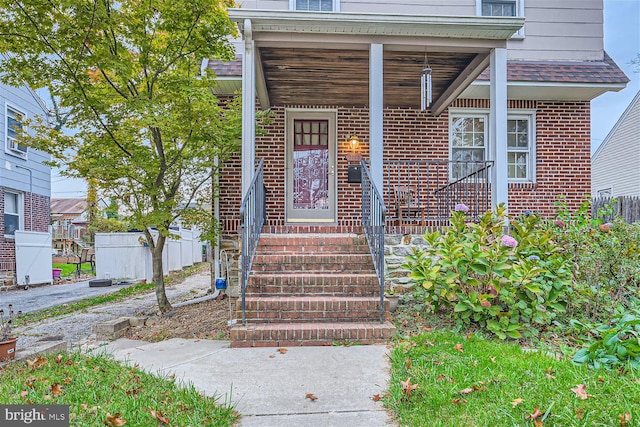 property entrance with brick siding and covered porch
