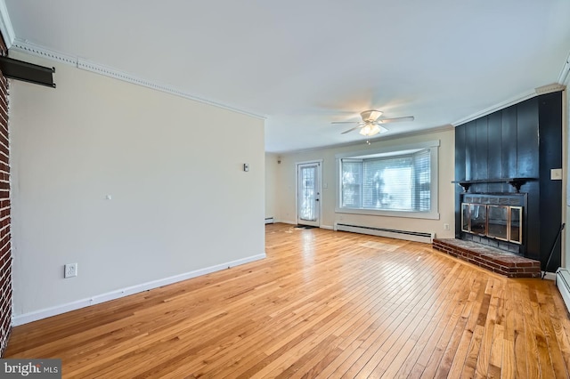 unfurnished living room featuring baseboard heating, a brick fireplace, ornamental molding, light wood-style floors, and a ceiling fan