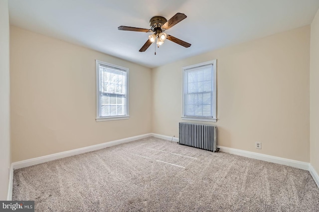 carpeted empty room with radiator heating unit, ceiling fan, and baseboards