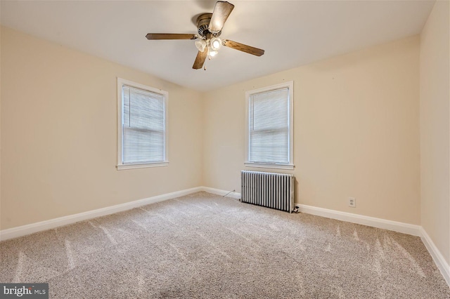unfurnished room with radiator heating unit, carpet, a ceiling fan, and baseboards