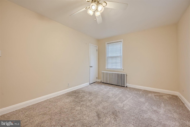 spare room with radiator, a ceiling fan, light colored carpet, and baseboards