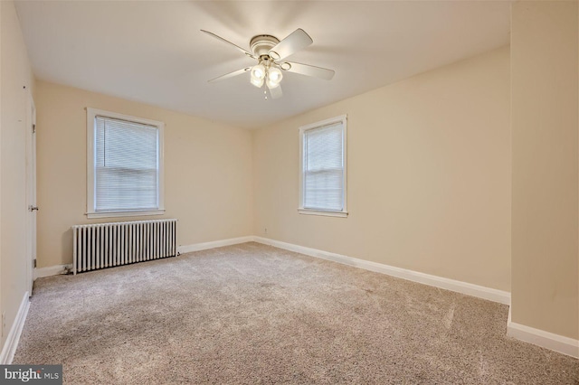 carpeted spare room with radiator heating unit, ceiling fan, and baseboards