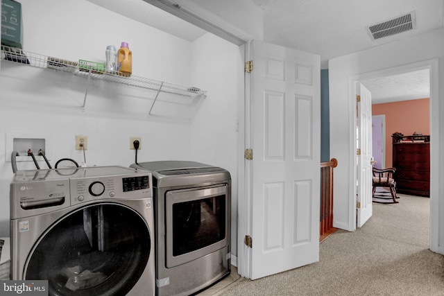 laundry room with visible vents, laundry area, washer and clothes dryer, and light colored carpet