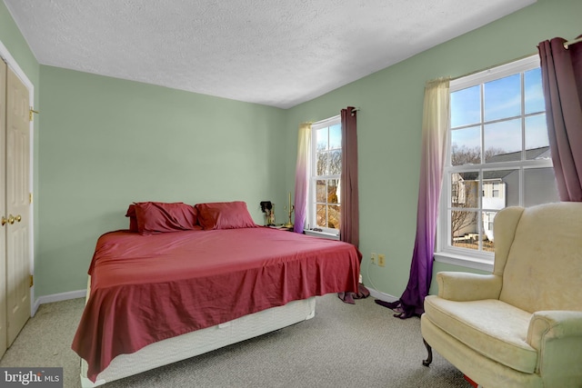 carpeted bedroom featuring baseboards and a textured ceiling