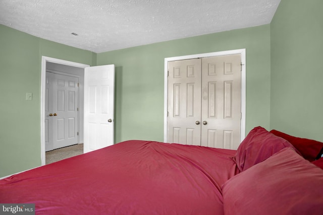 bedroom featuring carpet floors, a closet, and a textured ceiling