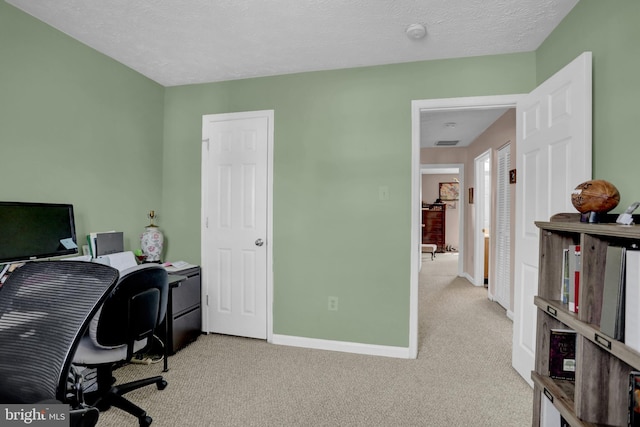 office area featuring baseboards, carpet flooring, a textured ceiling, and visible vents