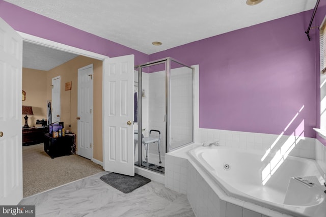 bathroom featuring marble finish floor, a textured ceiling, a stall shower, and a whirlpool tub