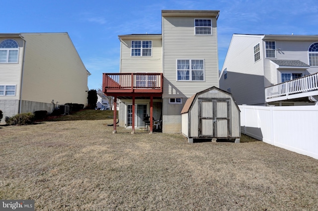 back of property with cooling unit, an outbuilding, a shed, fence, and a deck