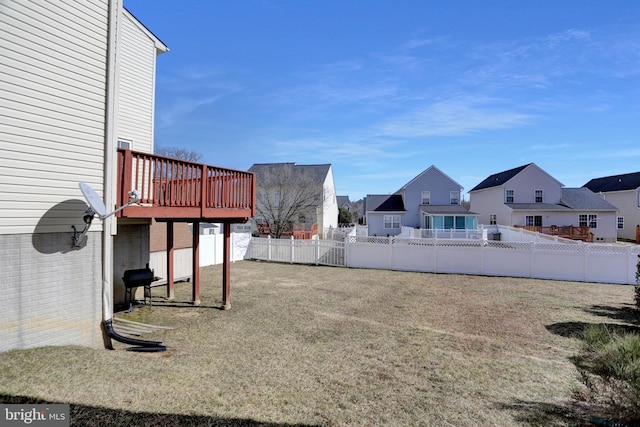 view of yard featuring a deck, aphalt driveway, a fenced backyard, a residential view, and a garage