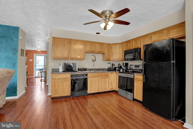 kitchen with a sink, ceiling fan, light brown cabinets, black appliances, and wood finished floors