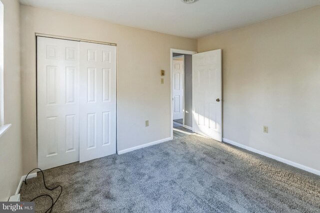 unfurnished bedroom with a closet, baseboards, and carpet