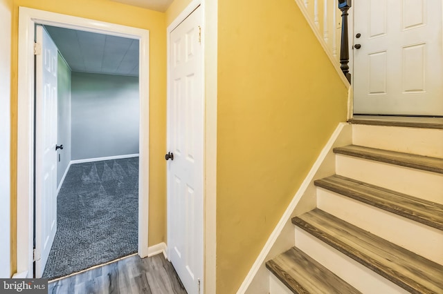 stairway with wood finished floors and baseboards