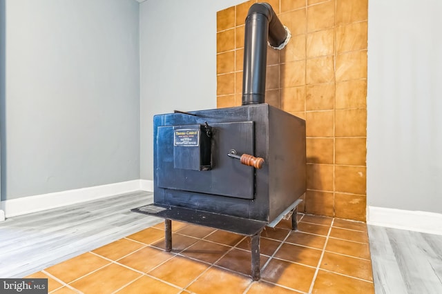 details featuring a wood stove, baseboards, and wood finished floors