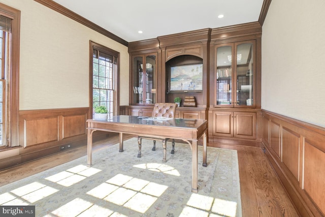 unfurnished office featuring a wainscoted wall, ornamental molding, light wood finished floors, and recessed lighting