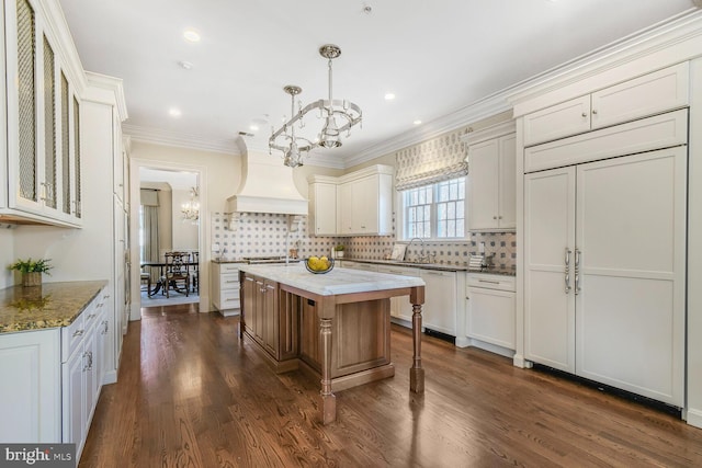 kitchen featuring custom range hood, a sink, a notable chandelier, and dishwasher