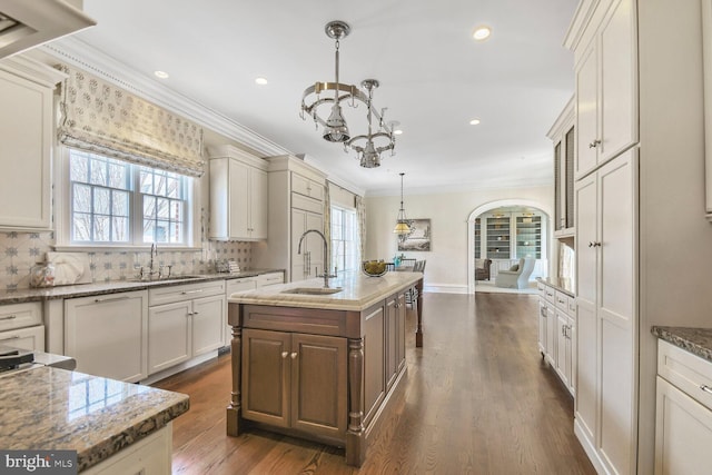 kitchen featuring a sink, ornamental molding, a chandelier, and dark wood finished floors