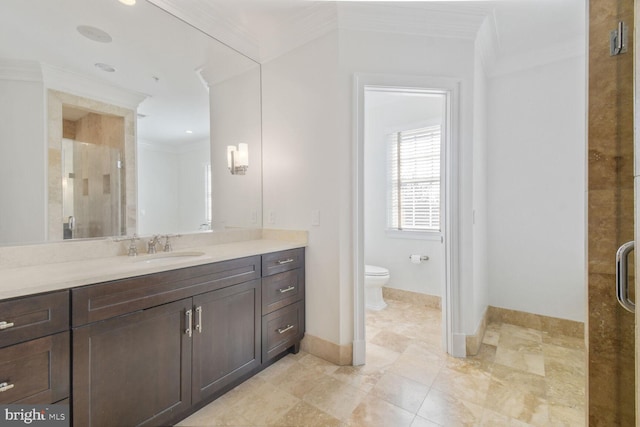 full bath featuring crown molding, toilet, vanity, a shower stall, and baseboards