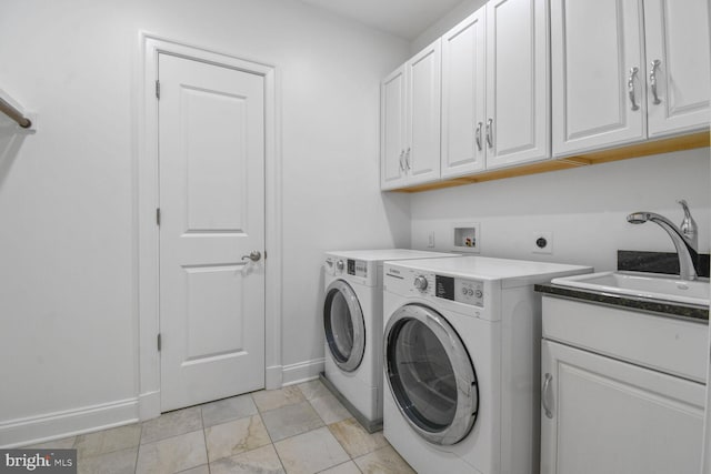 laundry area with independent washer and dryer, cabinet space, a sink, and baseboards