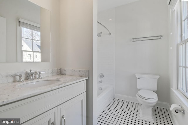 bathroom with tile patterned floors, toilet, vanity, shower / bathing tub combination, and baseboards