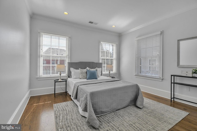 bedroom featuring ornamental molding, baseboards, and wood finished floors