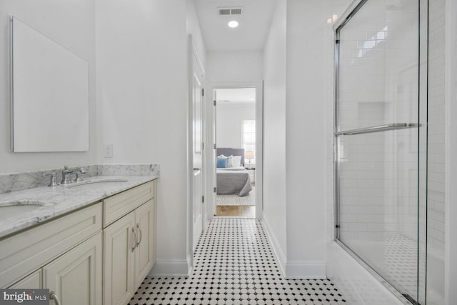 ensuite bathroom with visible vents, baseboards, double vanity, a sink, and ensuite bath