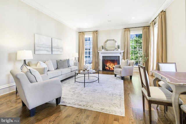 living area featuring a fireplace with flush hearth, baseboards, crown molding, and wood finished floors