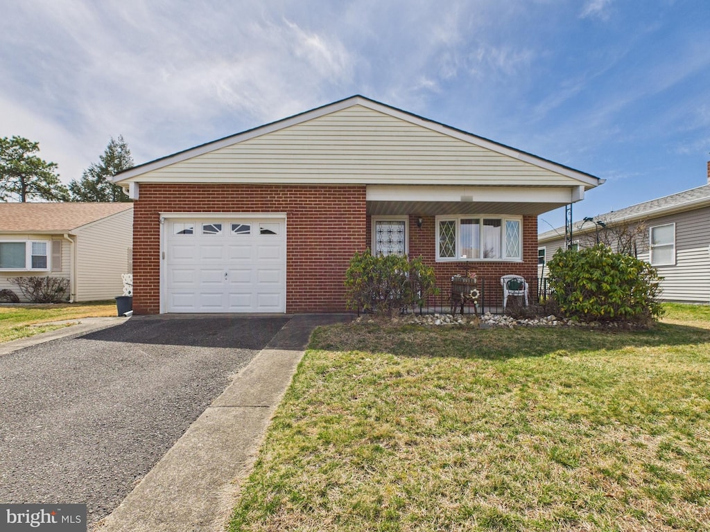 view of front of house with a front lawn, brick siding, aphalt driveway, and an attached garage