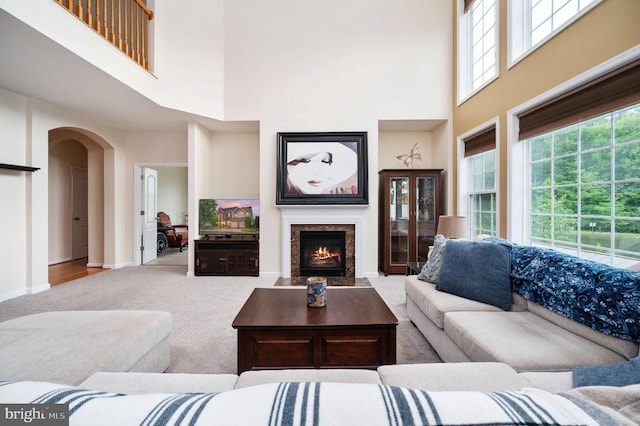16647 Space More Cir, Woodbridge, VA 22191 - carpeted living area featuring a high ceiling, arched walkways, plenty of natural light, and baseboards