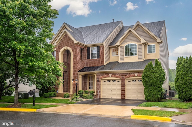 16647 Space More Cir, Woodbridge, VA 22191 - view of front facade featuring a garage, brick siding, concrete driveway, and roof with shingles