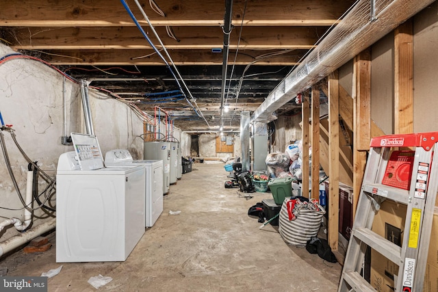 unfinished basement with electric water heater and washer and clothes dryer