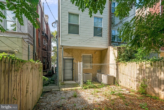 back of property featuring fence and cooling unit