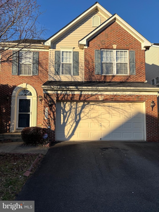 traditional-style house with brick siding, driveway, and a garage