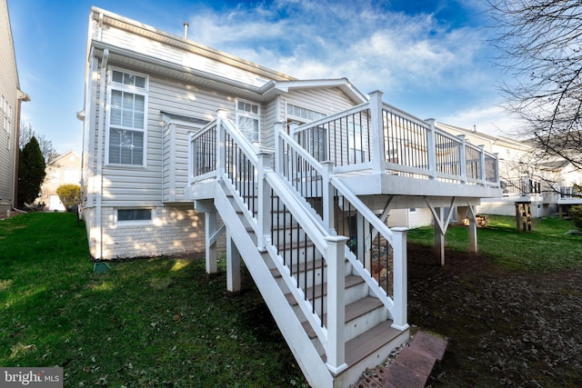 back of property featuring a deck, stairway, and a yard