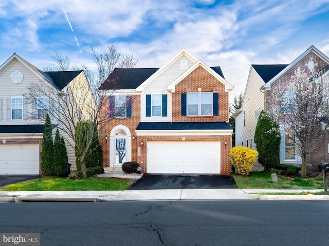 view of front of home with brick siding, driveway, and a garage