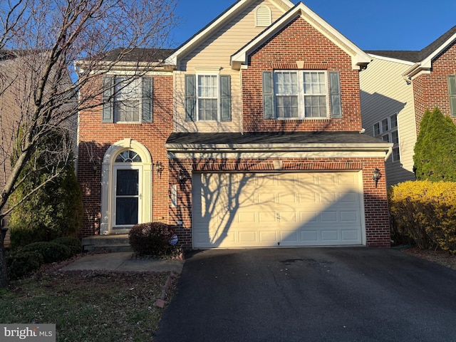 traditional-style home featuring driveway, brick siding, and a garage