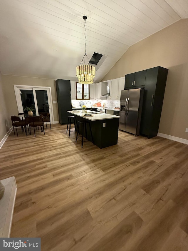 1198 Glenside Rd, Downingtown, PA 19335 - kitchen featuring light countertops, wall chimney range hood, lofted ceiling, and stainless steel refrigerator with ice dispenser