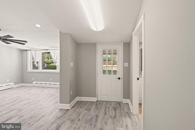 entryway with baseboards, baseboard heating, a ceiling fan, and wood finished floors