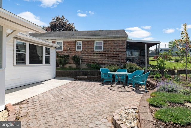 view of patio / terrace featuring a sunroom and fence