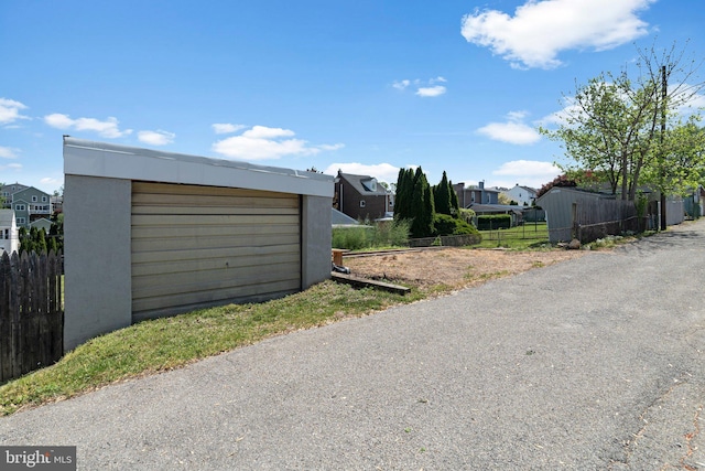 exterior space with fence, a residential view, and driveway