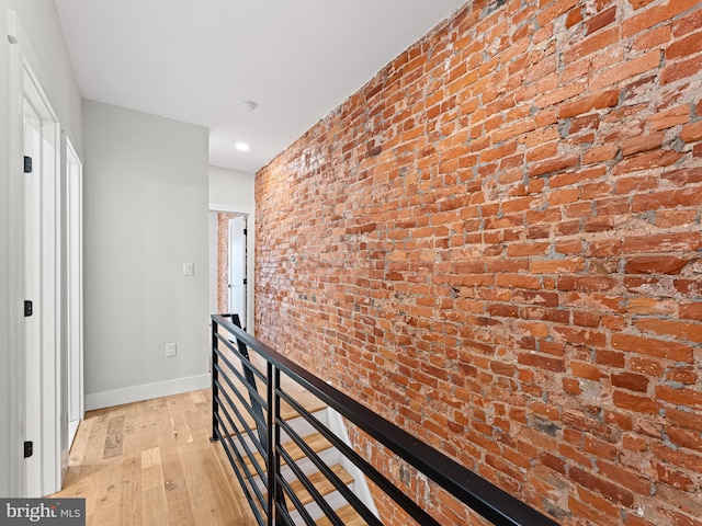 1611 N Dover St, Philadelphia, PA 19121 - hall with light wood finished floors, an upstairs landing, brick wall, and baseboards