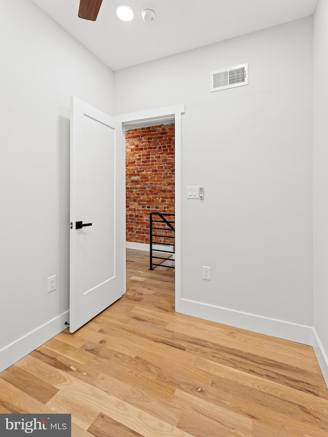 1611 N Dover St, Philadelphia, PA 19121 - unfurnished room with a ceiling fan, baseboards, brick wall, visible vents, and light wood finished floors