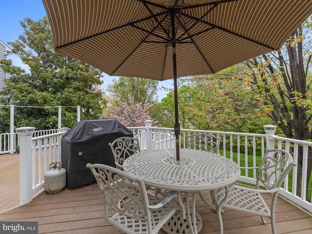 wooden terrace featuring a grill and outdoor dining space