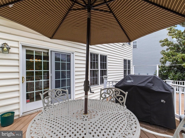 wooden deck featuring outdoor dining space and grilling area