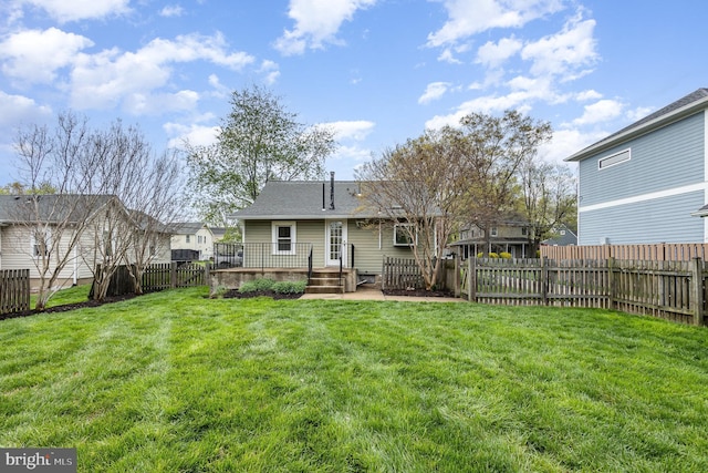 rear view of property with a fenced backyard, a wooden deck, and a yard