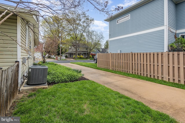 view of yard with central AC and fence