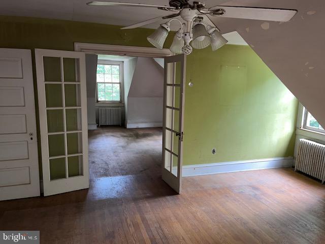 605 Upland Rd, Pikesville, MD 21208 - additional living space featuring ceiling fan, french doors, wood finished floors, and radiator heating unit