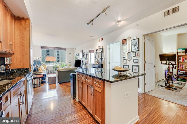 440 L St NW Unit 513, Washington, DC 20001 - kitchen featuring dishwasher, visible vents, light wood-style floors, a kitchen island, and dark stone counters